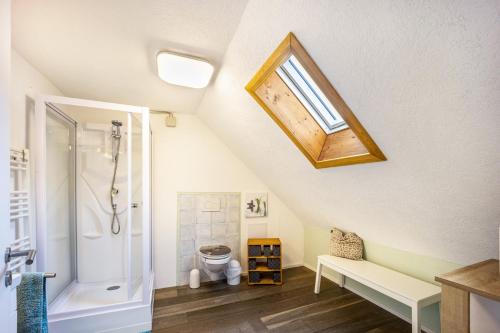 a attic bathroom with a shower and a bench at Salty Sol in Leutkirch im Allgäu