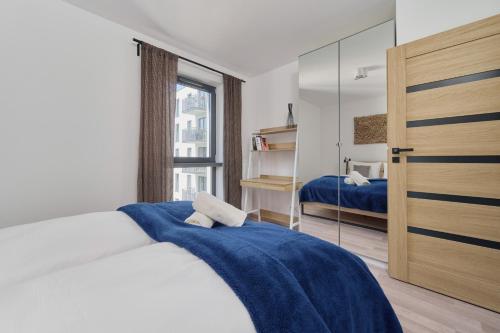 um quarto com uma cama com um cobertor azul em City Center Mirrors Apartment with Parking by Renters em Breslávia