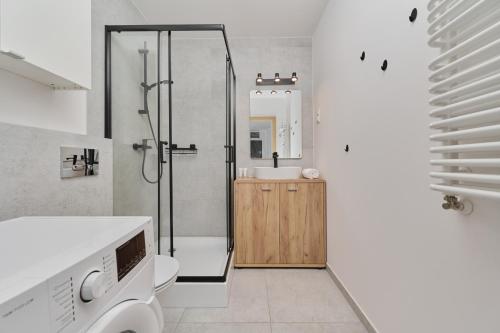 uma casa de banho com um chuveiro e um lavatório. em City Center Mirrors Apartment with Parking by Renters em Breslávia
