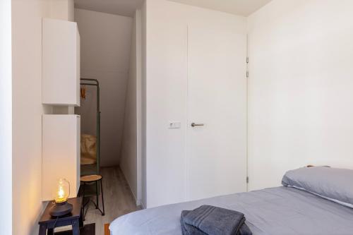 een slaapkamer met een bed en een kamer met een kast bij Hertog 1 Modern and perfectly located apartment in Eindhoven