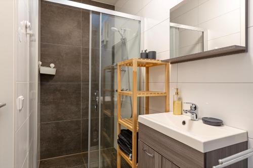 y baño con lavabo y ducha. en Hertog 1 Modern and perfectly located apartment en Eindhoven