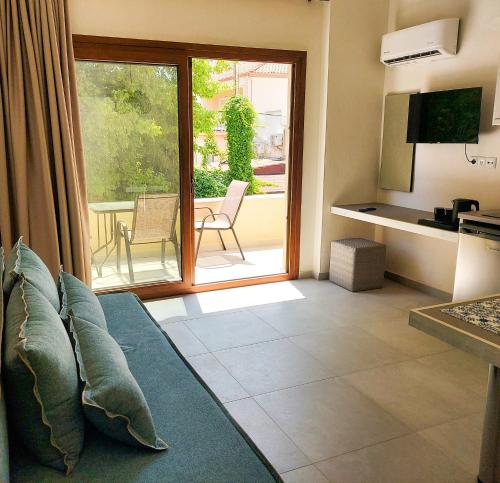 un salon avec un canapé et une porte coulissante en verre dans l'établissement Naiades Urban Thassos, à Thasos