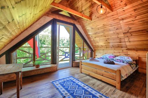 1 dormitorio con 1 cama en una cabaña de madera en Domek z Piernika 729-656-514, en Ropienka