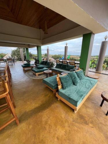 a living room with couches and tables on a patio at Heart and Soul Lodge in Karatu