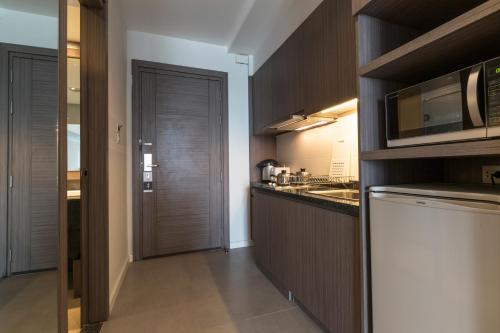 a kitchen with a sink and a microwave at Kantary Hotel Korat in Nakhon Ratchasima