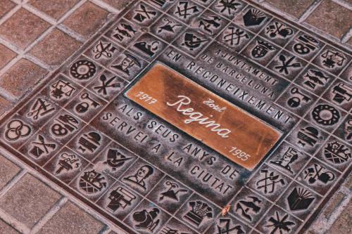 a metal manhole cover with a sign on it at Hotel Regina Barcelona in Barcelona