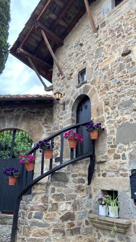 a stone building with potted plants on a balcony at LITTLE TOWER in Potes