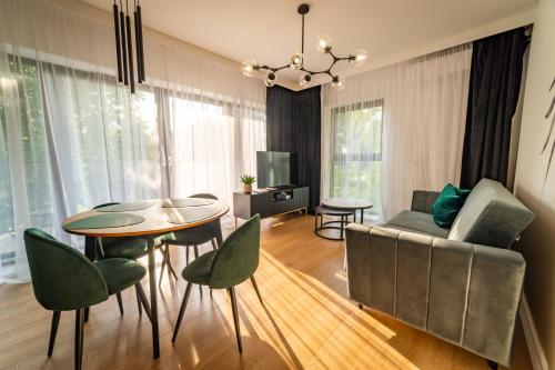 uma sala de estar com uma mesa e cadeiras e um sofá em Lake Rental Spacerowa em Mikolajki