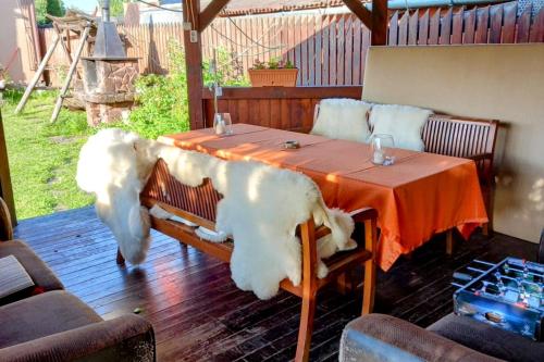 une table avec un grand chien blanc assis devant elle dans l'établissement Lend apartman in the garden, à Miercurea-Ciuc