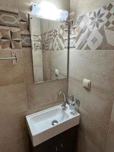 a bathroom with a sink and a mirror at Amarandos Studios Village Bliss in Fodele