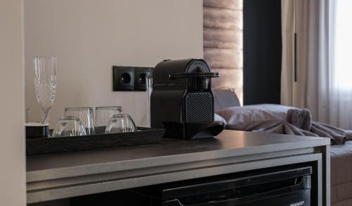 a table with glasses and a coffee maker on it at Golden Island Resorts in Athens