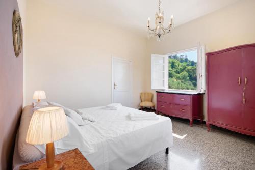 a bedroom with a bed with a red dresser and a window at Villa Mesco in Levanto