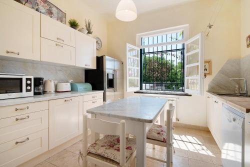 a kitchen with white cabinets and a table and chairs at Villa Mesco in Levanto