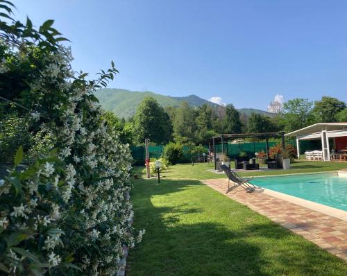 un jardín con un banco junto a una piscina en CasaD, en San Gillio