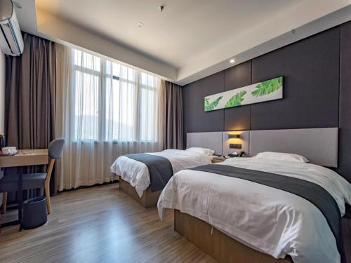 a hotel room with two beds and a desk and a window at Thank Inn Chain Hotel Guangdong Qingyuan Fogang County 106 National Road in Qingyuan