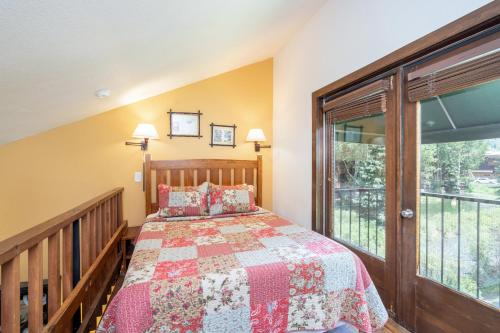 ein Schlafzimmer mit einem Bett und einem großen Fenster in der Unterkunft Manitou Lodge 6 Hotel Room in Telluride