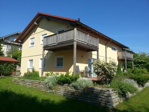 a house with a balcony on top of a stone wall at meywohnen Bad Endorf in Bad Endorf