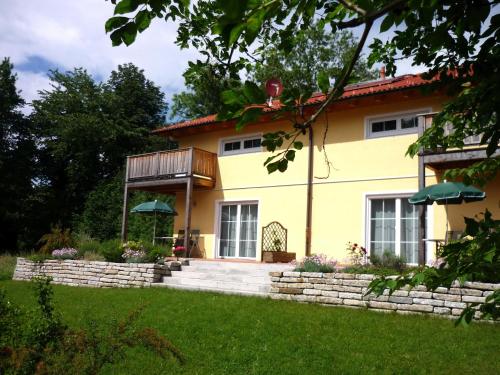a yellow house with a stone wall at meywohnen Bad Endorf in Bad Endorf