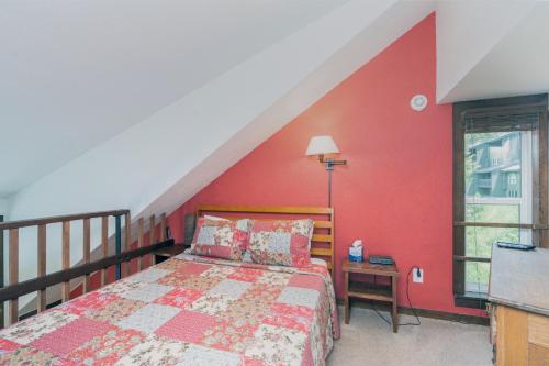 ein Schlafzimmer mit einem Bett und einer roten Wand in der Unterkunft Manitou Lodge 11 Hotel Room in Telluride