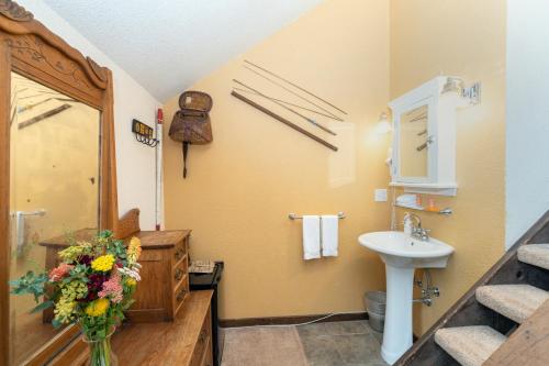 baño con lavabo y jarrón de flores en Manitou Lodge 8 Hotel Room, en Telluride