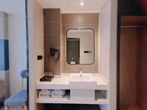 uma casa de banho com um lavatório e um espelho em Thank Inn Plus Hotel Mianyang Normal University em Mianyang