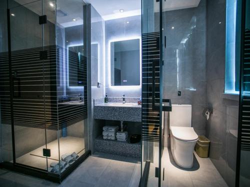 ein Bad mit einer Dusche, einem WC und einem Waschbecken in der Unterkunft Thank Inn Plus Cangzhou Weiming Road Huabei Commercial Building in Cangzhou