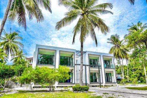 a building with palm trees in front of it at Am Samui Resort Taling Ngam in Taling Ngam Beach