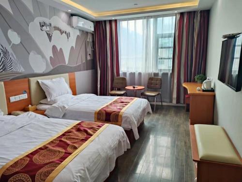 a hotel room with two beds and a desk at Thank Inn Plus Hotel Henan Luoyan Yanshi Luosheng Building in Yanshi