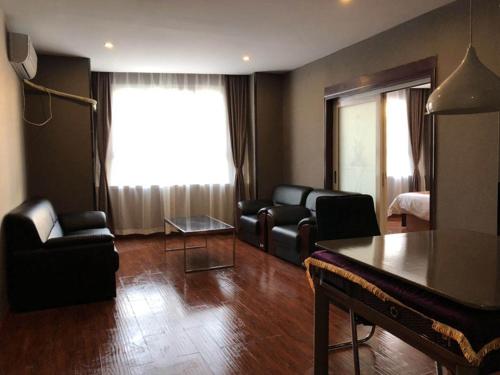 a living room with a couch and a table at JUN Hotels Henan Anyang Yindu DIstrict Tiexi Road in Anyang