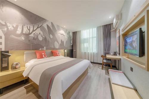 Cette chambre comprend un grand lit et une télévision à écran plat. dans l'établissement Thank Inn Chain Hotel Lanshan District Yitang, à Linyi