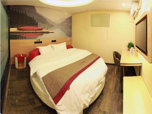 a hotel room with a large bed and a tv at Thank Inn Plus Hotel Henan Luoyang Luolong University Zhang Heng Street City in Luoyang