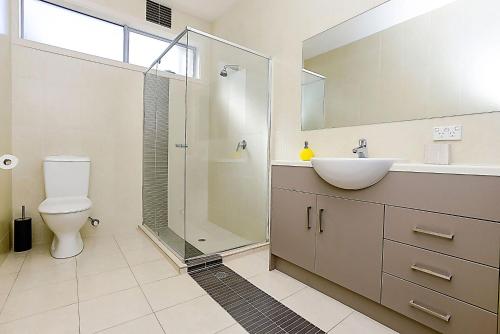 a bathroom with a toilet and a sink and a shower at Luxury and Beachfront on Franklin in Encounter Bay