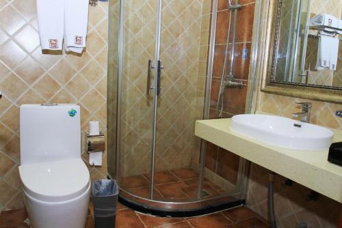 a bathroom with a shower and a toilet and a sink at JUNYI Hotel Hebei Zhangjiakou West Bridge District Ciershan Street in Zhangjiakou