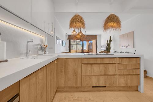 uma cozinha com armários de madeira e um grande lavatório em Villa Gadea 7-2 em Altea