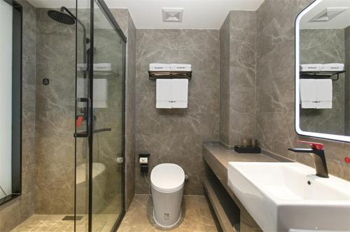 a bathroom with a toilet and a sink and a shower at Thank Inn Chain Hotel Shanxi Yangquan Yu County West Xiushui Street in Yu