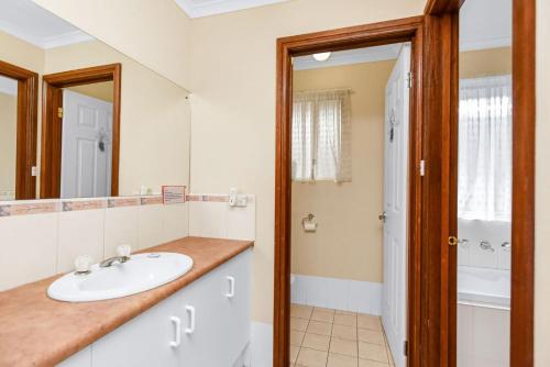 a bathroom with a sink and a mirror at Holiday Close to the Beach Park Swimming Centre in Hayborough