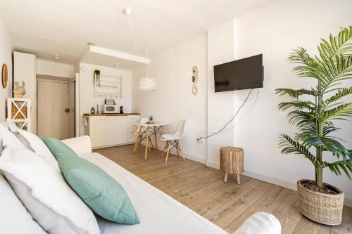 a living room with a bed and a tv on a wall at Apartamento Welcs EMP 054 Cerca del Mar in Empuriabrava