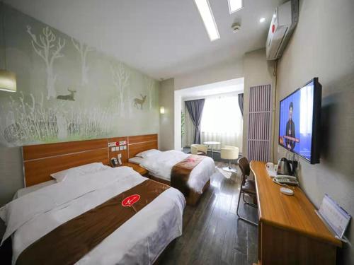 a hotel room with two beds and a flat screen tv at Thank Inn Chain Hotel Gansu Tianshui Taian Bus Station in Tianshui