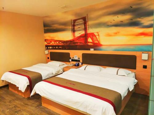 dwa łóżka w pokoju z obrazem na ścianie w obiekcie Thank Inn Plus Hotel Henan Luoyang Luolong University Zhang Heng Street City w mieście Luoyang