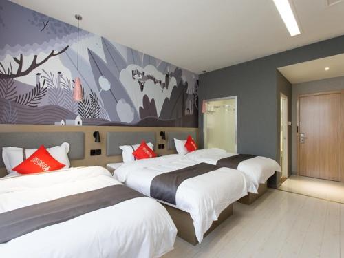 a bedroom with two beds and a painting on the wall at Thank Inn Chain Hotel Economic and Technological Development Zone Yihe Road in Linyi