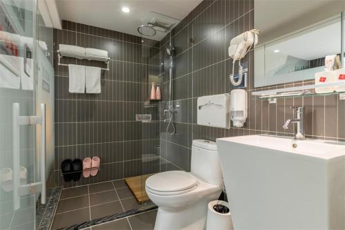 a bathroom with a toilet and a sink at Thank Inn Chain Hotel Lanshan District Yitang in Linyi