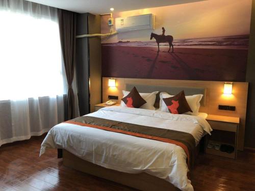 una habitación de hotel con una cama con un caballo en la pared en JUN Hotels Henan Anyang Yindu DIstrict Tiexi Road en Anyang