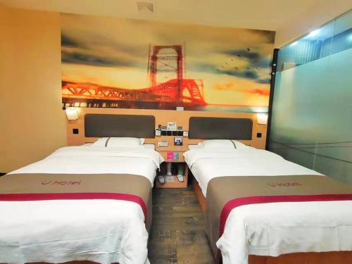 2 Betten in einem Zimmer mit Wandgemälde in der Unterkunft Thank Inn Plus Hotel Henan Luoyang Luolong University Zhang Heng Street City in Luoyang
