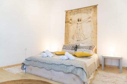 a bedroom with a bed with a painting on the wall at Nina's Traditional House by Estia in Valaneíon