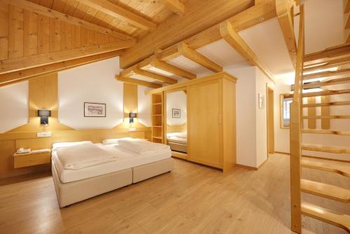 a bedroom with a bed in a room with wooden ceilings at Hotel Goldene Rose in Brunico