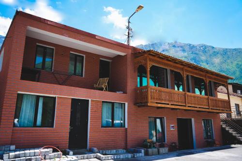 a red brick building with a balcony on it at Fiten house in Stepantsminda