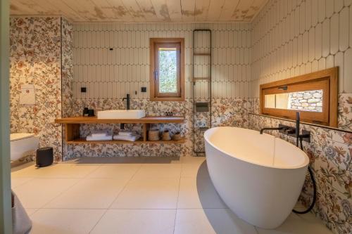 La salle de bains est pourvue d'une grande baignoire et de 2 lavabos. dans l'établissement Domaine de Casanghjulina, à Porto-Vecchio