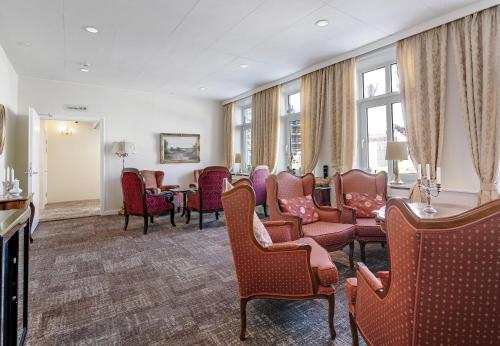 poczekalnia z krzesłami, stołem i oknami w obiekcie Hotel Postgaarden w mieście Fredericia