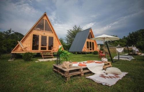 una cabaña en la hierba con una mesa y una sombrilla en VILLA ROKITI, en Rokit'i