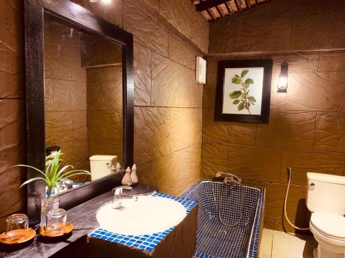 a bathroom with a sink and a mirror and a toilet at NeakBong Residence in Siem Reap